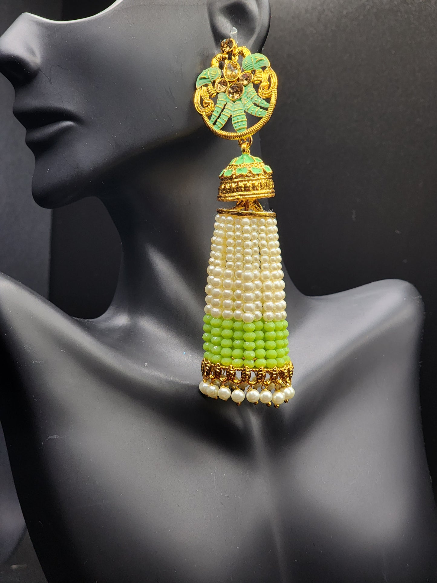 Bold, vibrant, and made to stand out. It's got rich enamel, intricate gold-tone work, and layered bead drops, this piece is desi