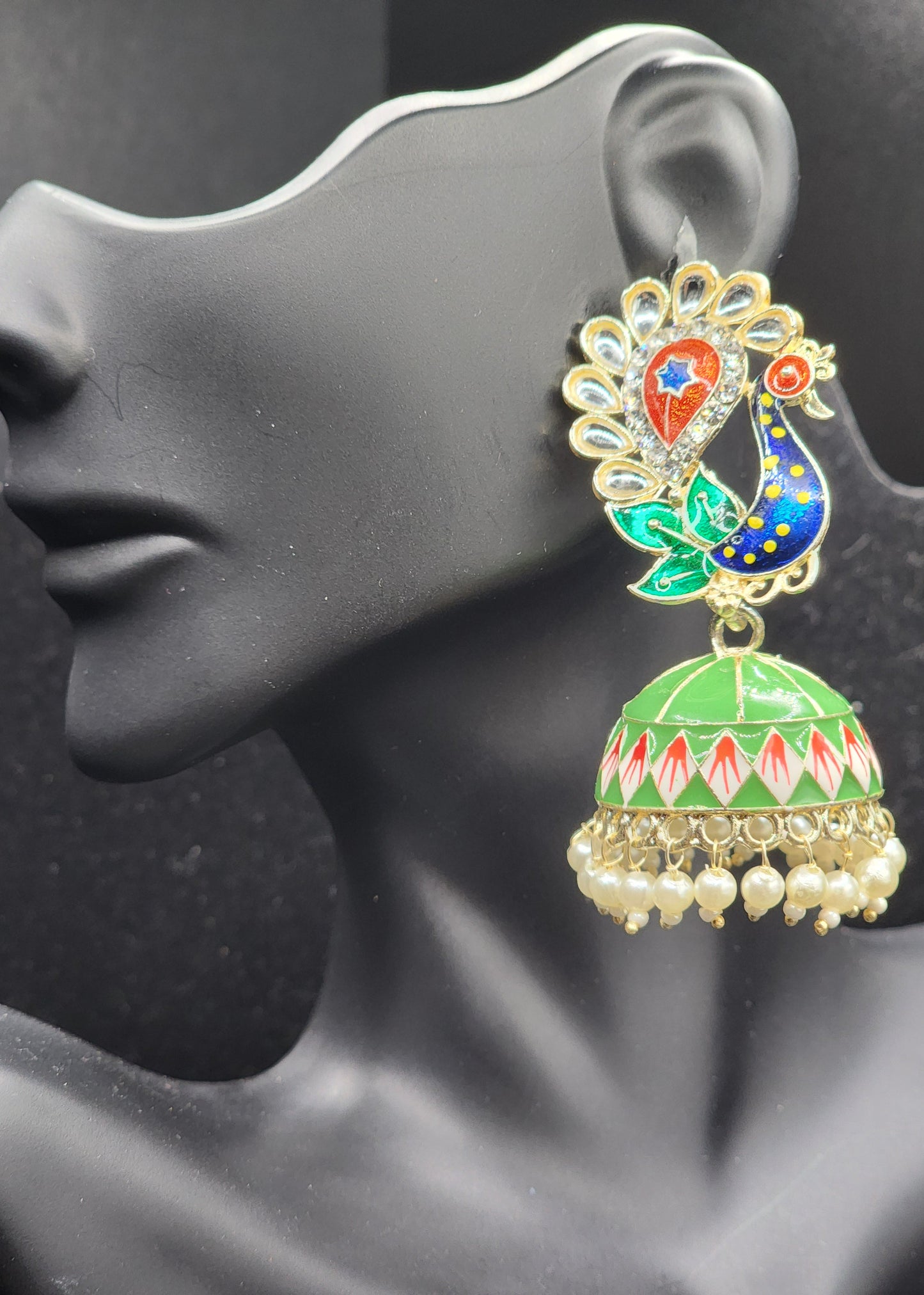 Bold, vibrant, and made to stand out. It's got rich enamel, intricate gold-tone work, and layered bead drops, this piece is desi
