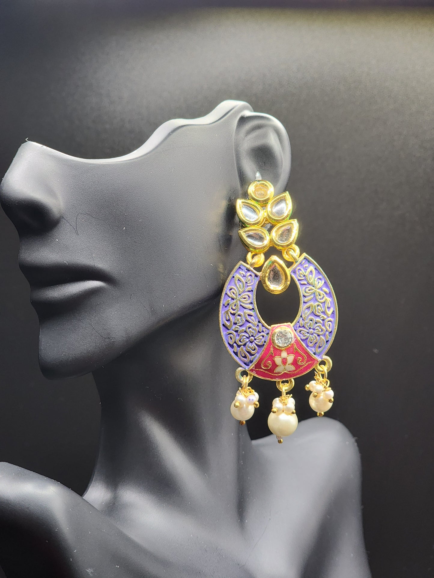 Bold, vibrant, and made to stand out. It's got rich enamel, intricate gold-tone work, and layered bead drops, this piece is desi