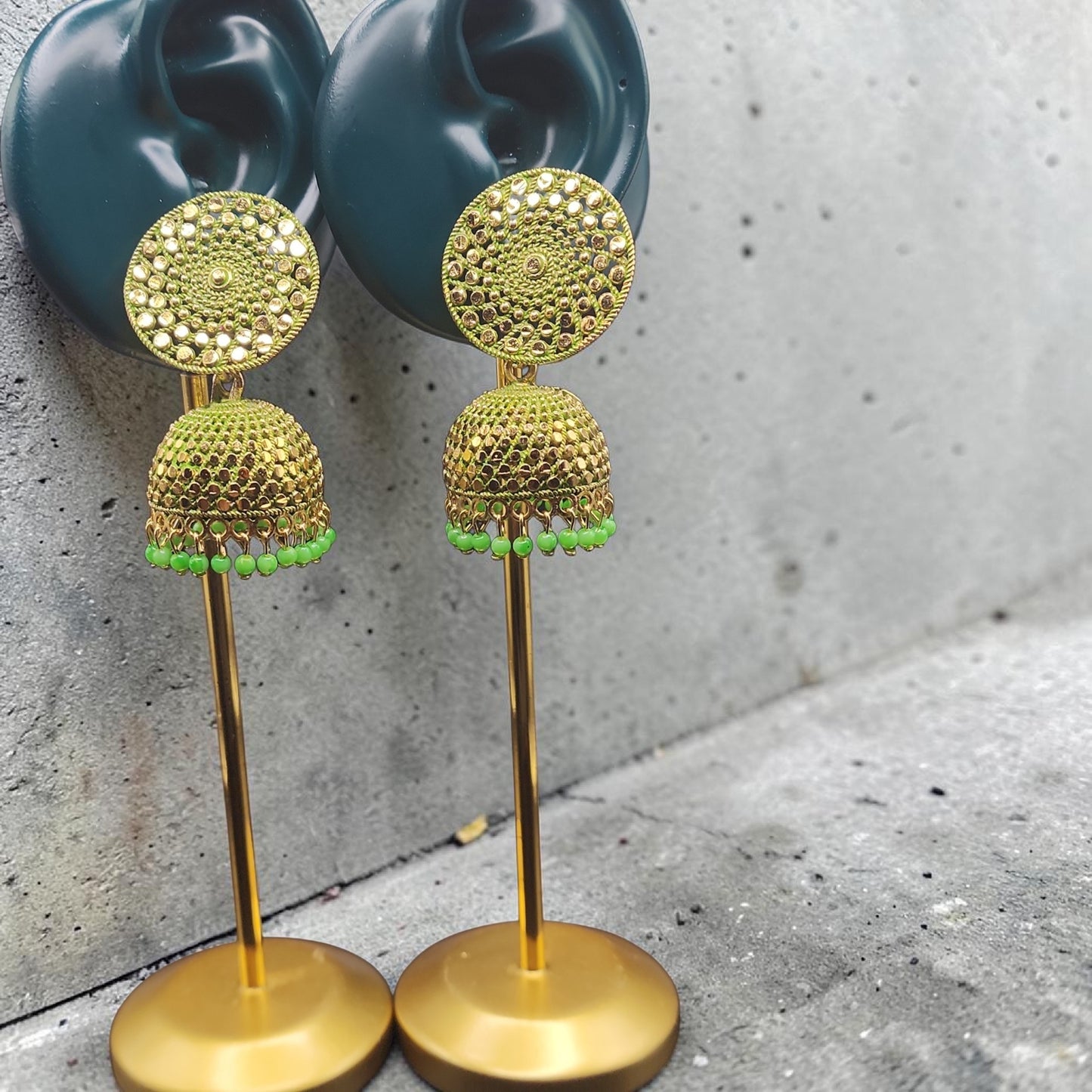 PSK ELEGANCE Gold Jhumka Earrings with Green Bead Detailing