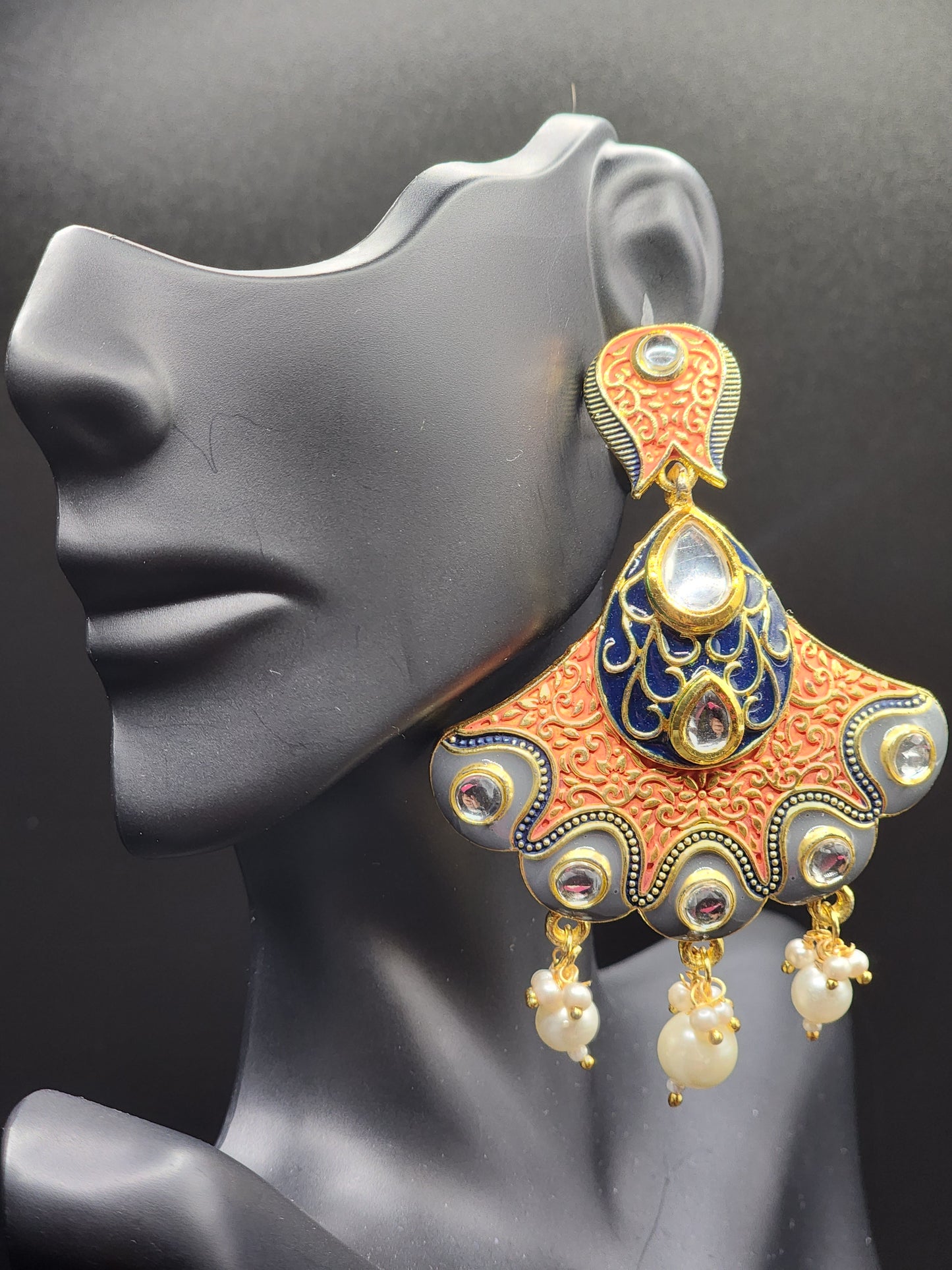 Bold, vibrant, and made to stand out. It's got rich enamel, intricate gold-tone work, and layered bead drops, this piece is desi