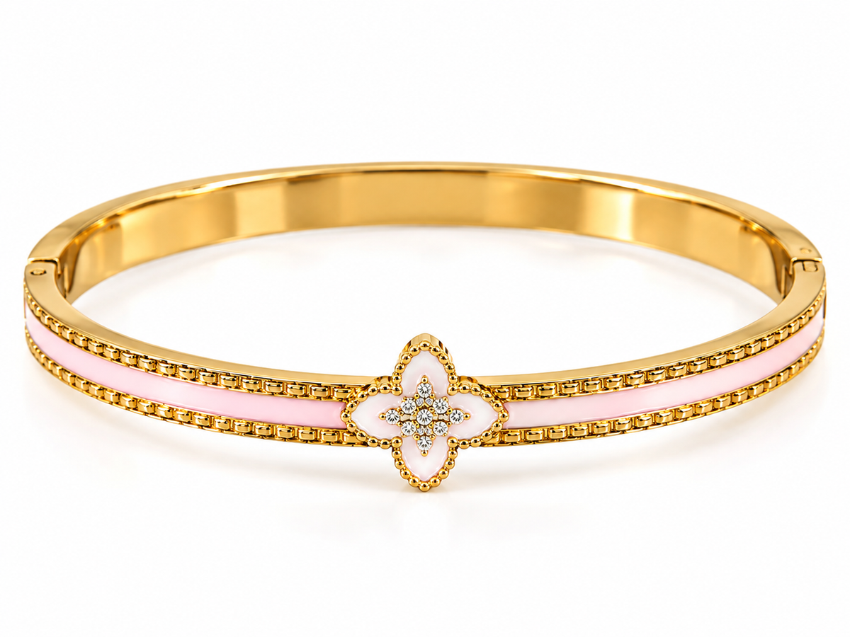 Gold-tone cuff bracelet with a blush pink enamel design and a delicate floral motif