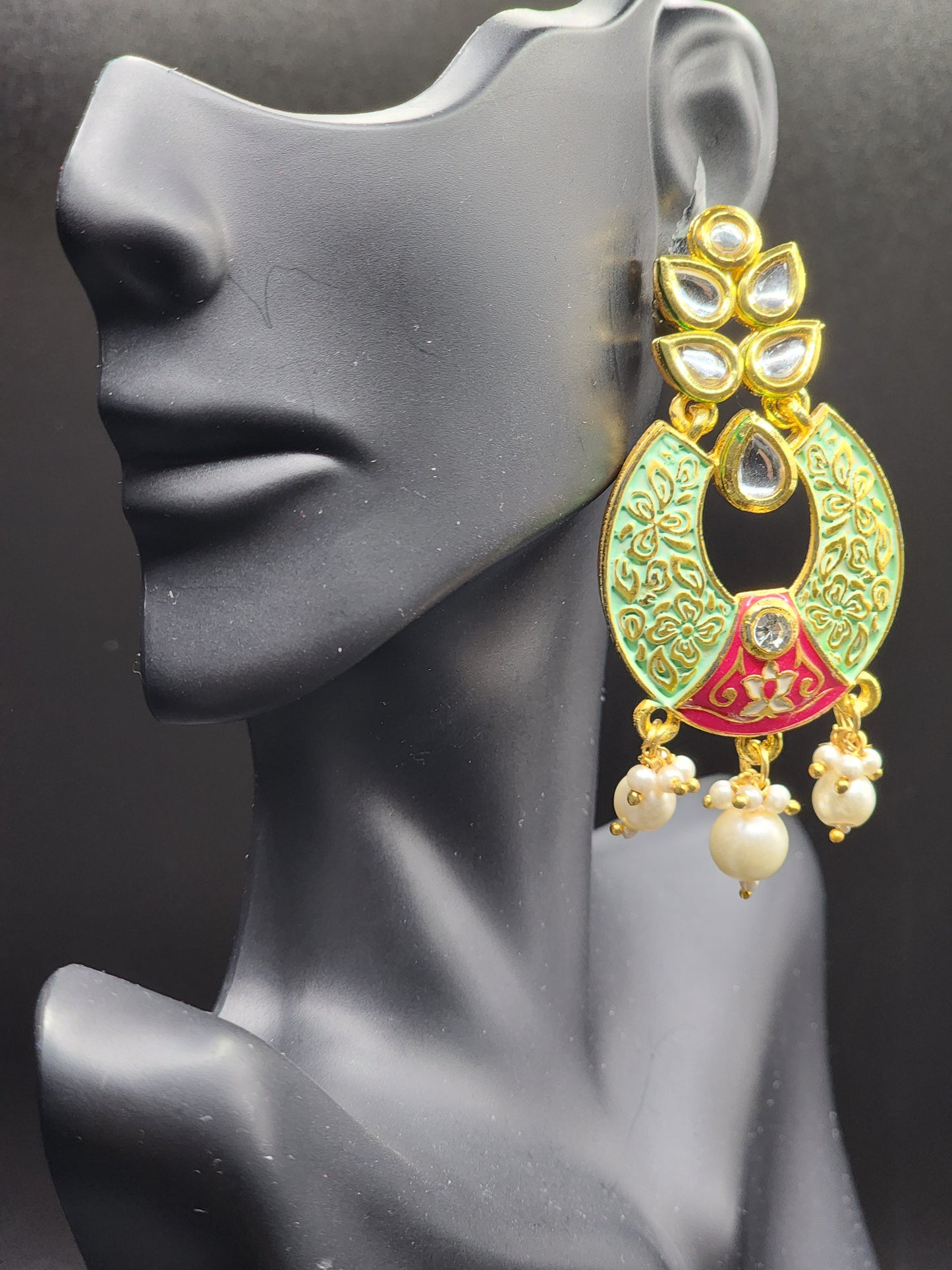 Bold, vibrant, and made to stand out. It's got rich enamel, intricate gold-tone work, and layered bead drops, this piece is desi