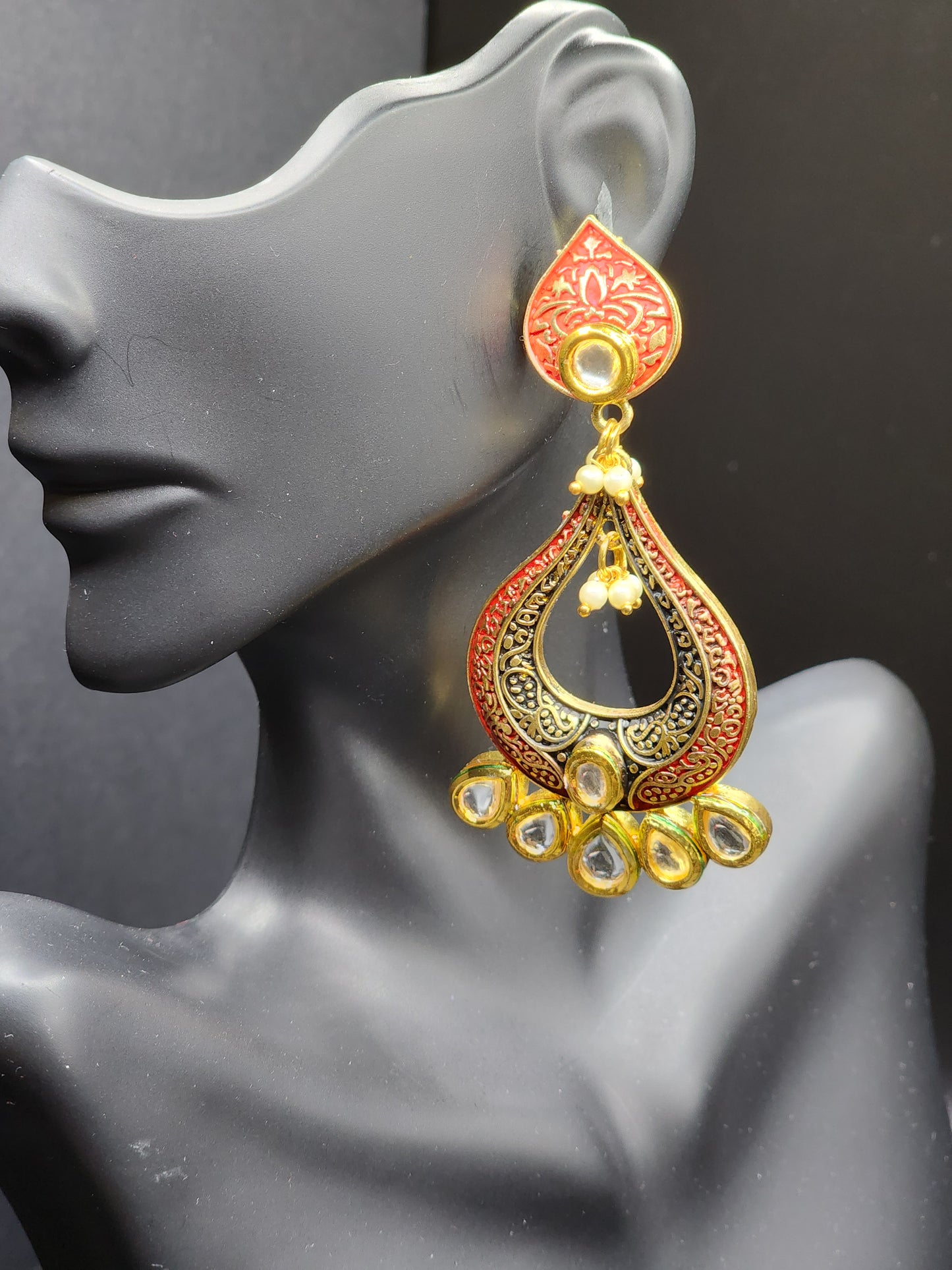 Bold, vibrant, and made to stand out. It's got rich enamel, intricate gold-tone work, and layered bead drops, this piece is desi