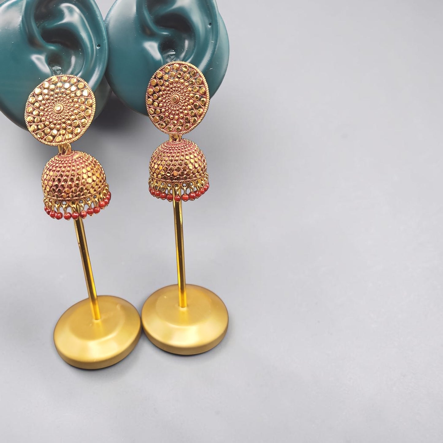 PSK ELEGANCE Gold Jhumka Earrings with Red Bead Detailing