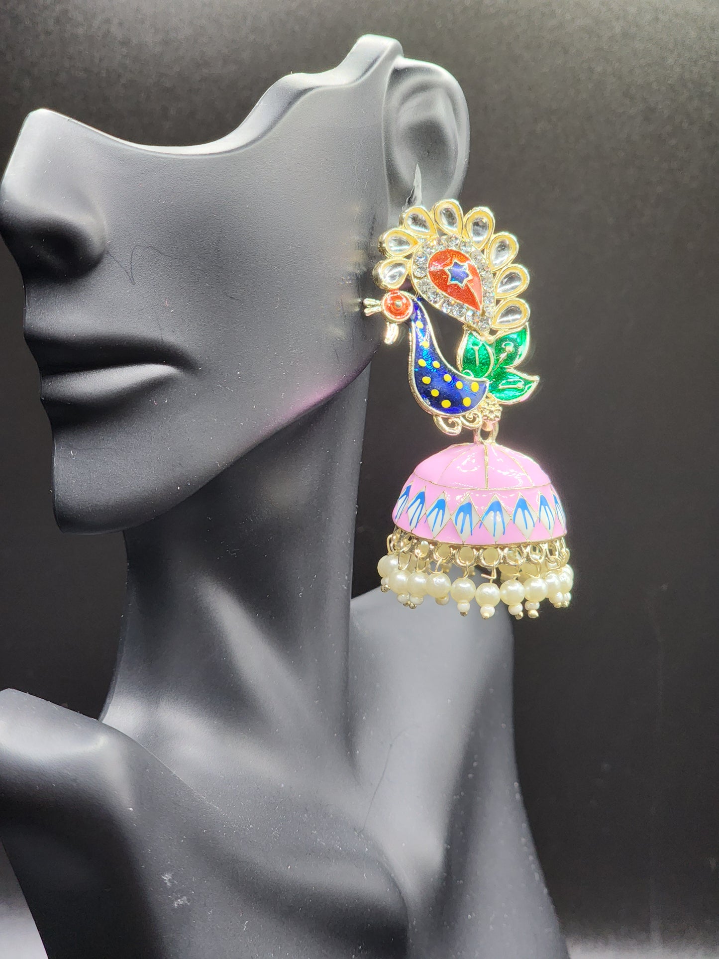 Bold, vibrant, and made to stand out. It's got rich enamel, intricate gold-tone work, and layered bead drops, this piece is desi