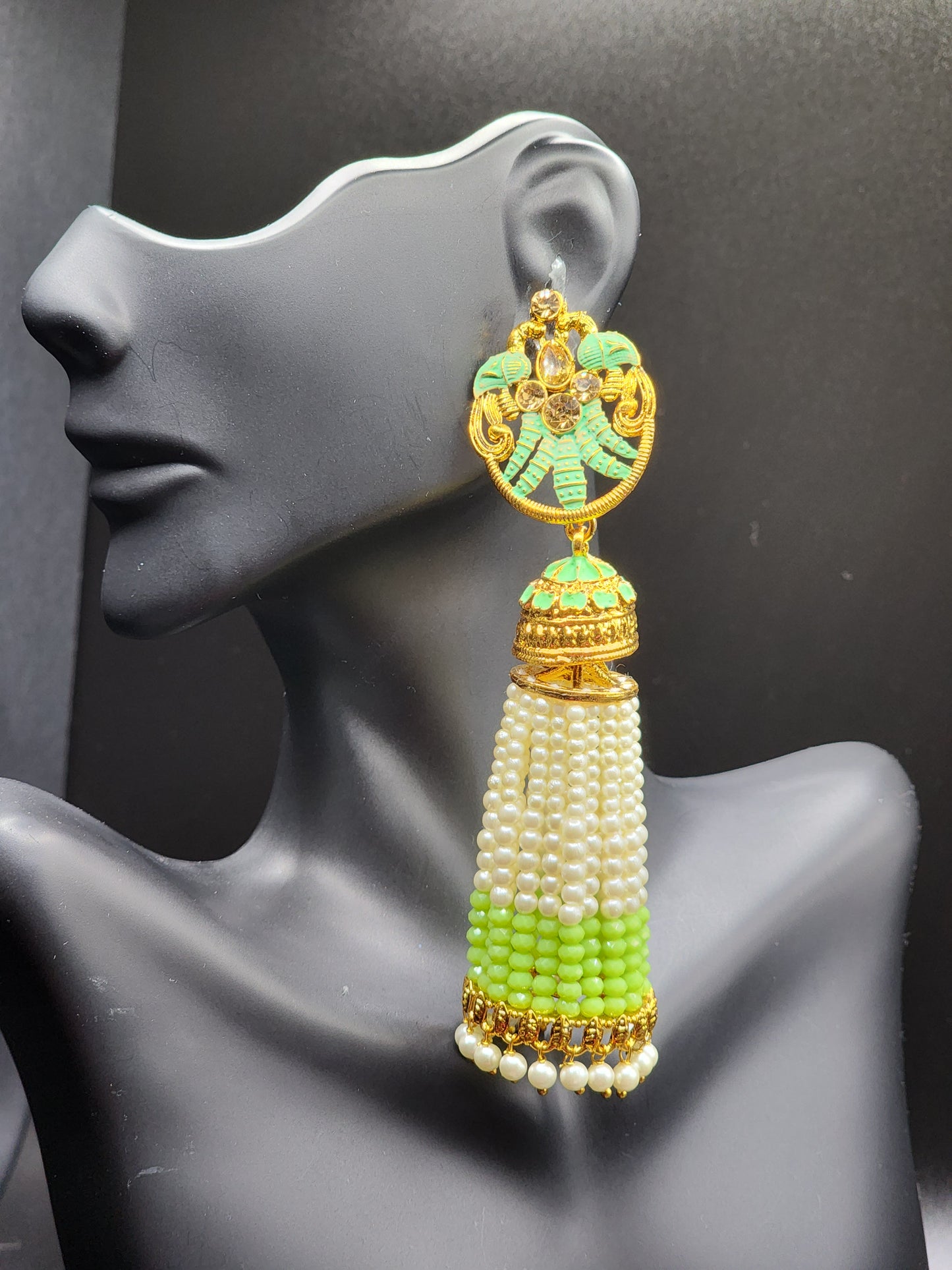 Bold, vibrant, and made to stand out. It's got rich enamel, intricate gold-tone work, and layered bead drops, this piece is desi