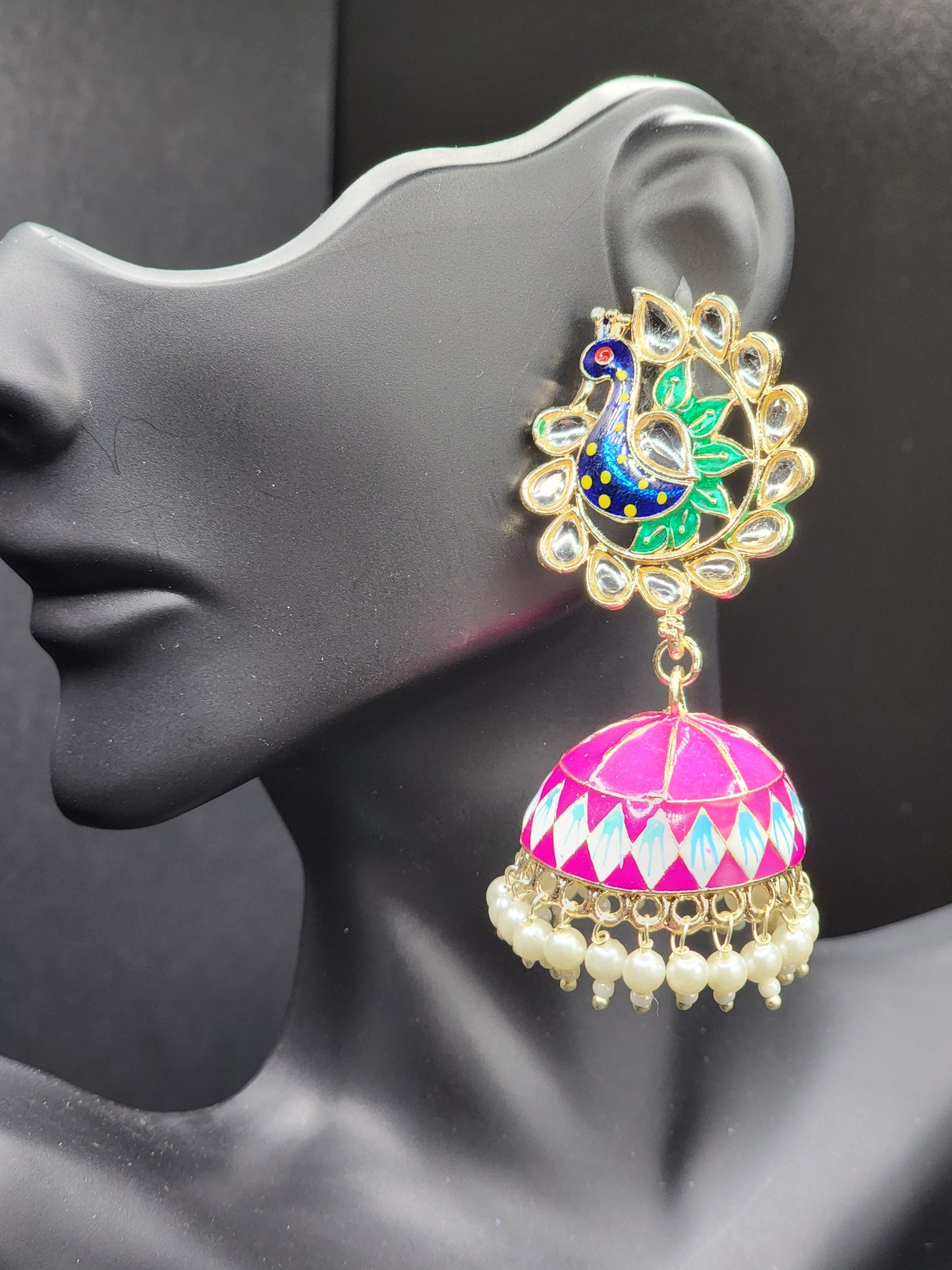 Bold, vibrant, and made to stand out. It's got rich enamel, intricate gold-tone work, and layered bead drops, this piece is desi