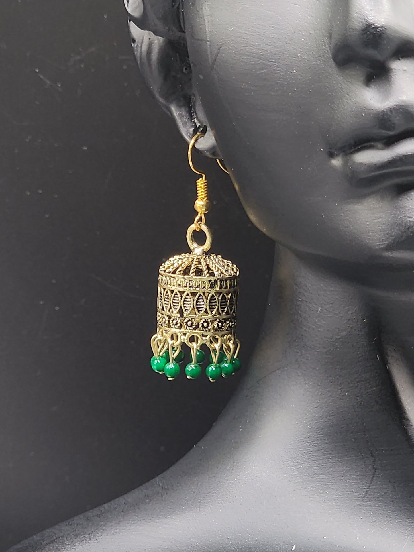 Pskelegance presents these exquisite gold jhumkas, adorned with emerald green drops.